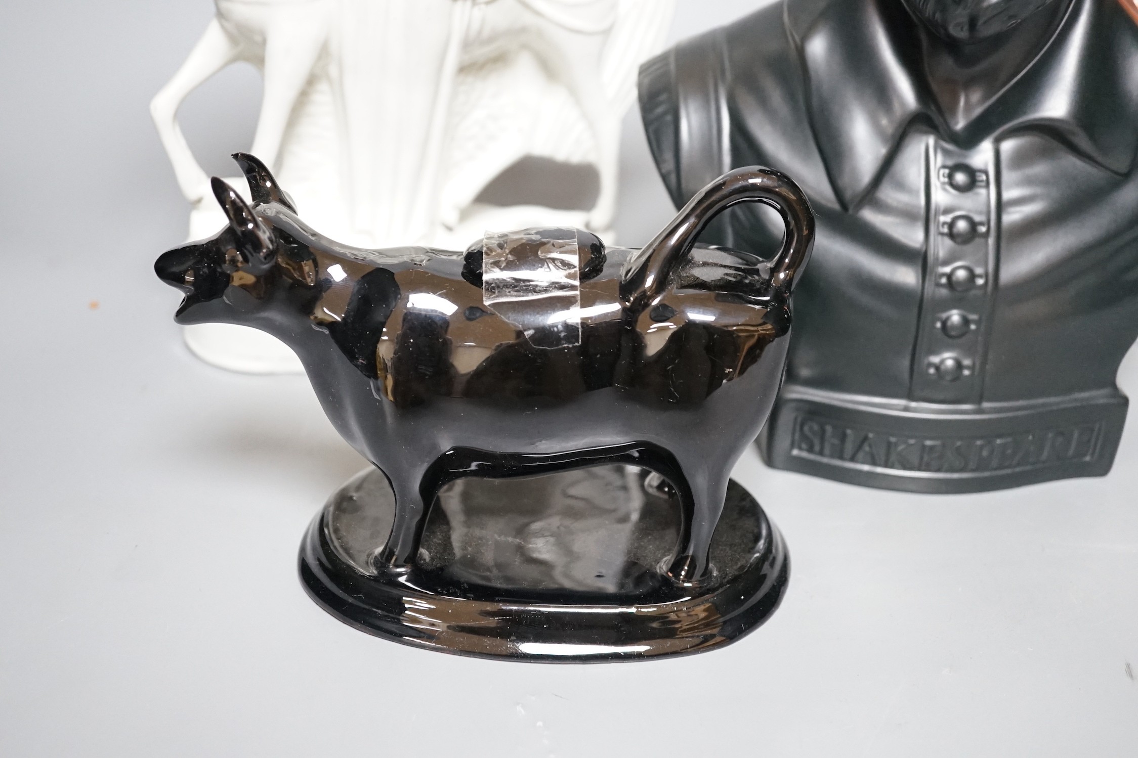 A Wedgwood glazed black basalt bust of Shakespeare, two Victorian Staffordshire figures and a cow creamer, tallest 27cm